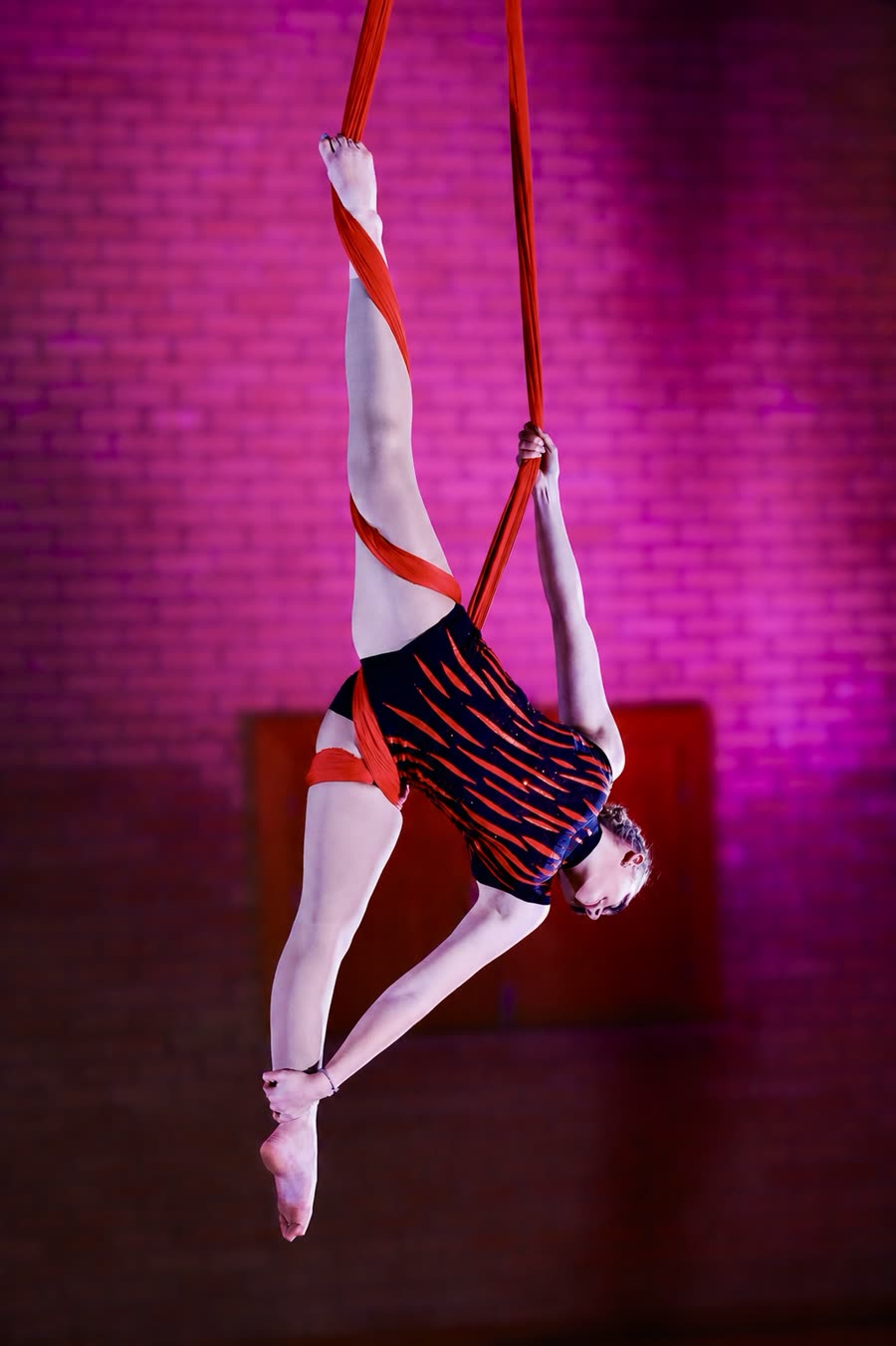 Aerial artist holding a shape on the hoop during a live show