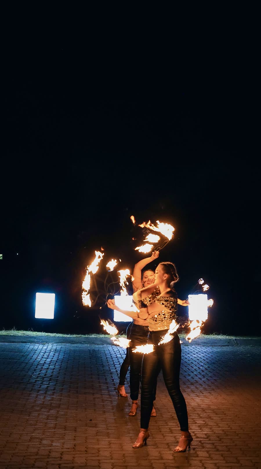 Fire dancers performing an outdoor night-time set